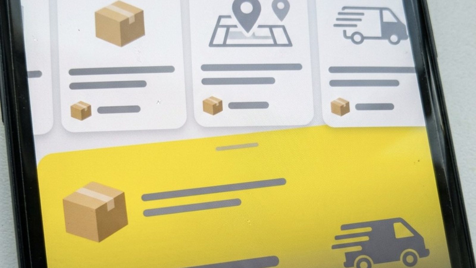 Tela de celular com cartões de caixas de papelão, mapa com marcadores e van de entrega sobre fundo amarelo, lembrando um aplicativo de coleta de produtos